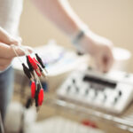 Close-up of a physiotherapist holding the cable of electro dry needling unit